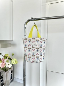 Détail du sac seau en coton matelassé avec anses jaunes et imprimés chien mignons