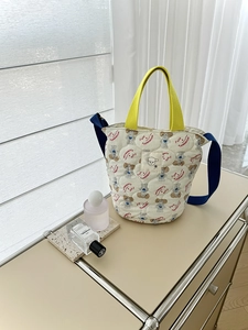 Détail du sac seau matelassé avec imprimé chien et anses jaune vif contrastées