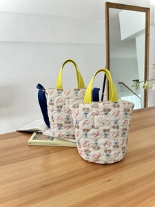 Détail du sac seau matelassé avec imprimés de chiens et bandoulière réglable