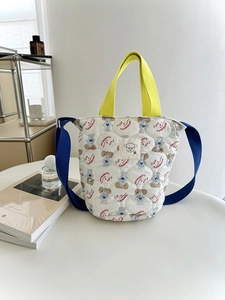Sac seau matelassé avec motifs de chiens, poignée jaune et bandoulière bleue
