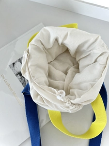 Sac seau matelassé bicolore avec fermeture à cordon et intérieur spacieux en détail