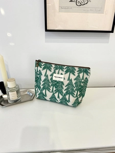 Close-up of cotton linen pouch with green pine embroidery and top zipper detail