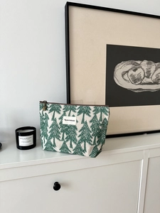 Detail view of cotton linen cosmetic bag with green pine embroidery and brown zipper