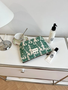 Detail of canvas toiletry bag with green pine tree embroidery and premium zipper closure