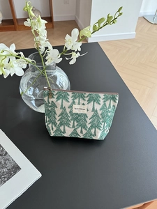 Detail of pine tree print cotton linen makeup bag with cute bear zipper pull and label