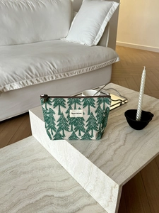 Detail of pine tree print on linen makeup bag with premium cotton logo and zipper