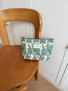 Detail of canvas toiletry bag with green pine tree pattern and Big star & little moon label