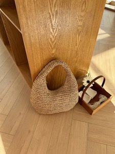 Detailed close-up of a handmade woven straw hobo bag with natural rustic texture