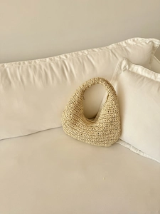 Close-up of beige hand-woven cloud shoulder bag in a premium straw hobo design