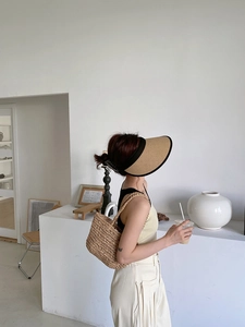 Detail of hand-woven straw tote bag and hollow sun hat for beach vacation style