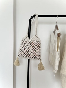 Détail du sac en paille fait main avec des pompons blancs et une doublure florale