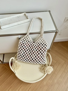 Vue détaillée du sac de plage crème avec doublure florale et décors de glands