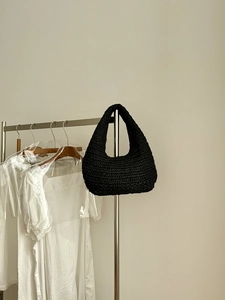 Detailed close-up of a black hand-woven cloud shoulder bag with a textured finish