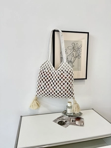 Détail du sac fourre-tout en macramé beige avec glands et poignée tressée robuste
