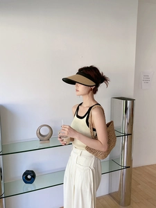 Minimalist straw tote bag and hollow visor hat styled with summer beach outfit