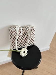 Détail du sac en paille avec motif de tissage évidé et doublure en tissu floral