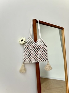 Détail du sac fourre-tout en paille fait main blanc avec glands et doublure fleurie