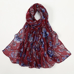 Détail d'une écharpe bordeaux à imprimé floral avec des motifs de fleurs bleues