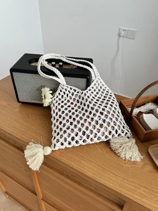Détail macro du sac cabas en maille tisse main avec doublure florale et pompons