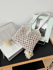 Détail d'un sac en paille macramé avec motif en losange et doublure florale