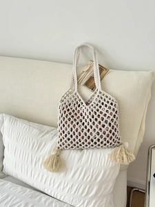 Gros plan d'un sac cabas en paille fait main avec glands et doublure à motifs floraux