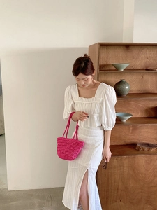 Detail of white puff sleeve crop top and high slit skirt set in soft cotton linen