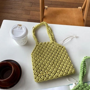 Détail du sac à main en paille tressée vert citron clair avec anses tressées