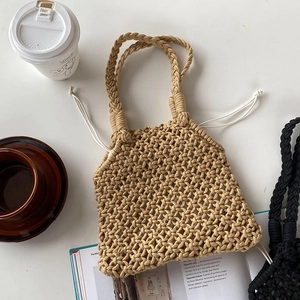Détail d'un sac cabas en paille tissé à la main avec texture ajourée et cordon de serrage