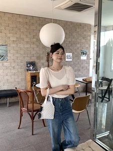 Tenue chic avec haut blanc cassé à manches bouffantes et sac à main tissé blanc