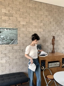 Détail d'un mini sac à main blanc tissé ajouré avec une tenue d'été en coton