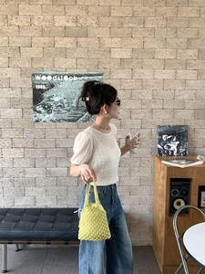 Détail du sac seau en paille tressée vert citron avec doublure à cordon et poignée