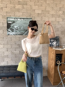 Détail d'un sac à main en paille tissé jaune vif avec une doublure blanche à cordon
