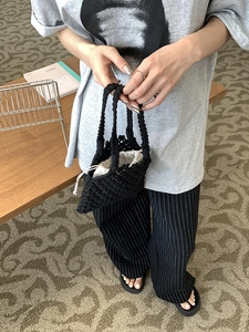 Détail du sac à main tissé à la main en maille noire avec doublure en toile blanche