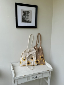 Detailed view of handmade sunflower crochet tote bags in cream and brown with tassels