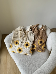 Detail of sunflower crochet tote bags in beige and brown with tassel woven handles
