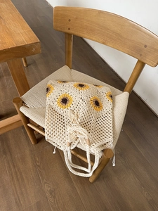 Close-up of handmade crochet flower tote with hollow mesh weave and sunflower details
