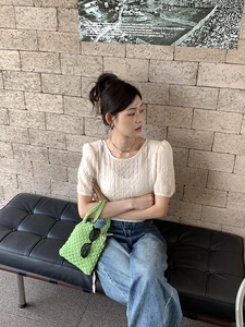 Tenue d'été à la mode avec haut blanc, jean denim et sac à main en crochet vert