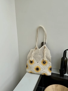 Detail of sunflower crochet tote bag featuring handmade floral knit and tassel accents