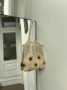 Detail of sunflower crochet tote bag with openwork knit and decorative fringe strap