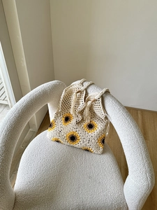 Detail of sunflower crochet pattern and cotton weave texture on a bohemian beach bag