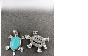 Detailed view of the turquoise turtle pendant brooch with silver metal finish