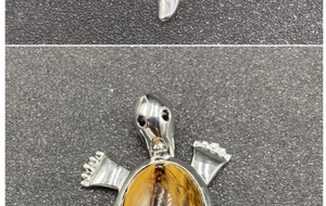 Macro detail of turtle pendant showing silver plating and tiger eye stone inlay