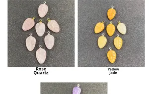 Detail von handgeschnitzten Anhängern aus Rosenquarz und gelber Jade in Blattform