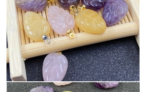 Macro shot of leaf-shaped amethyst and rose quartz pendants with fine engravings