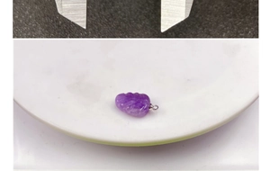 Macro shot of leaf-shaped purple amethyst pendant showing natural stone texture