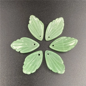 Detailed view of six hand-carved green jadeite leaf pendants for jewelry making