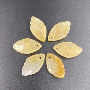 Macro detail of six yellow jade leaf pendants with fine vein carvings and top drill holes