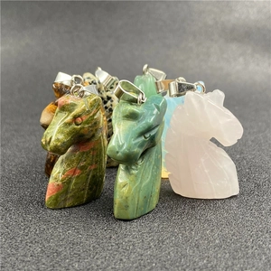 Detailed close-up of unicorn horse head pendants carved from natural tiger eye and quartz stones