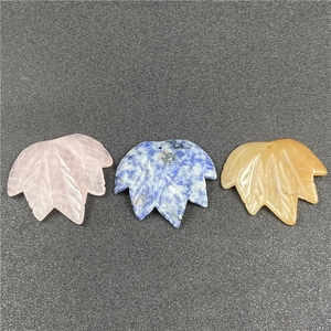 Detailed view of hand-carved maple leaf pendants made of quartz and various natural stones