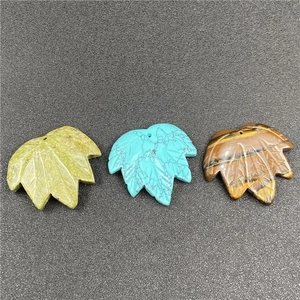Macro detail of maple leaf carved stone pendants in tiger eye and quartz stone texture